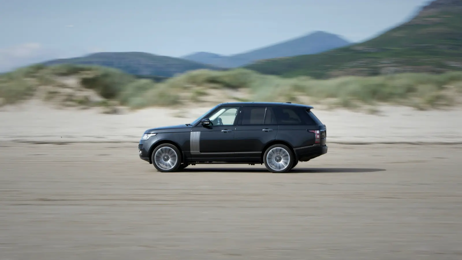 Range Rover on a sandy road by the sea, dark grey